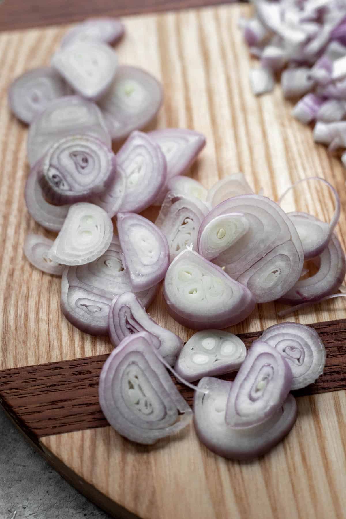 Rings of sliced shallots on a cutting board.