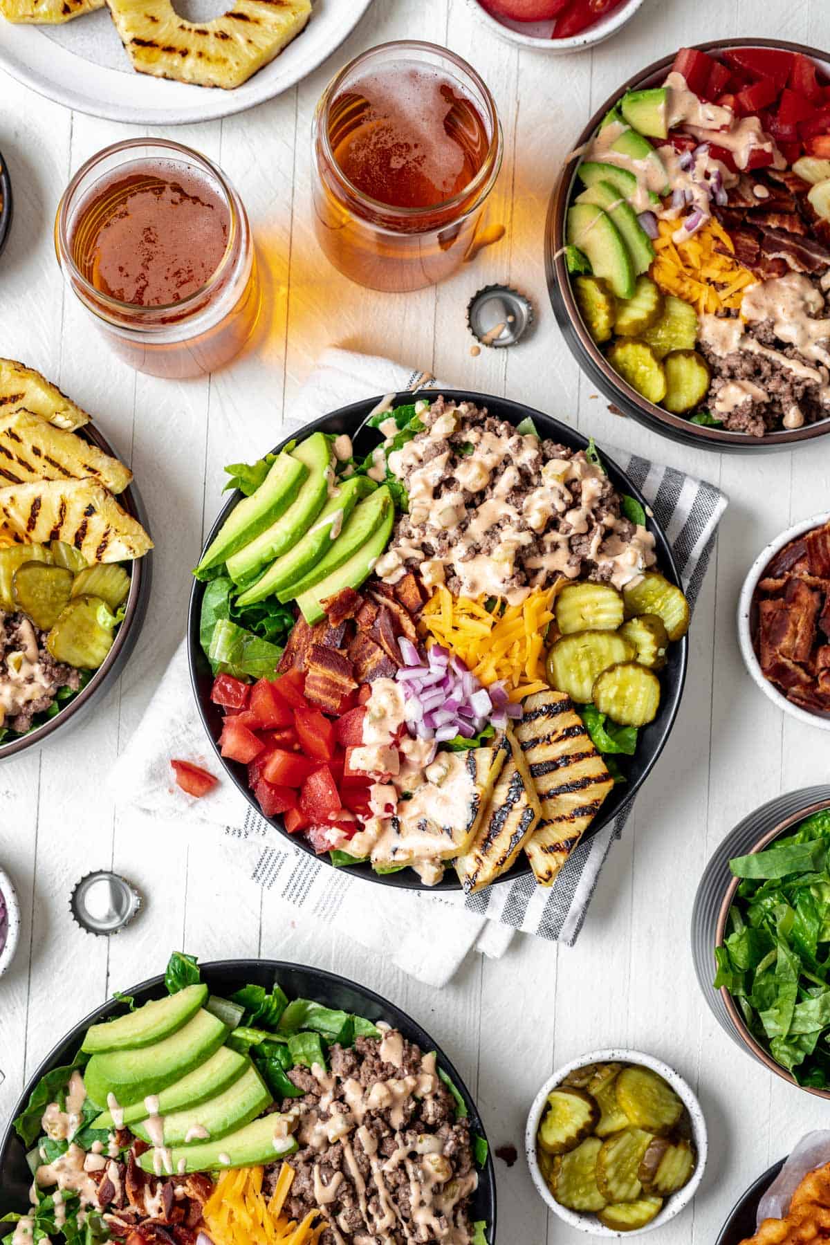 4 burger bowls topped with all the fixings and a drizzle of fry sauce.