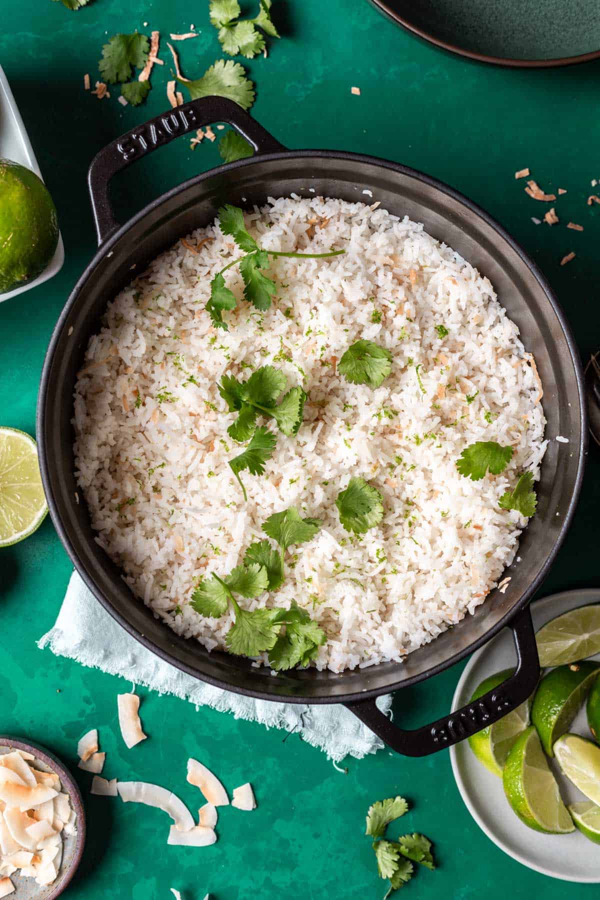 Coconut lime rice topped with cilantro in a black pot.