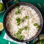 Coconut lime rice in a black pot with cilantro on top.
