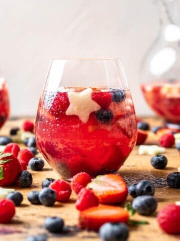 Berries and star shaped fruit in a wine glass with sangria.