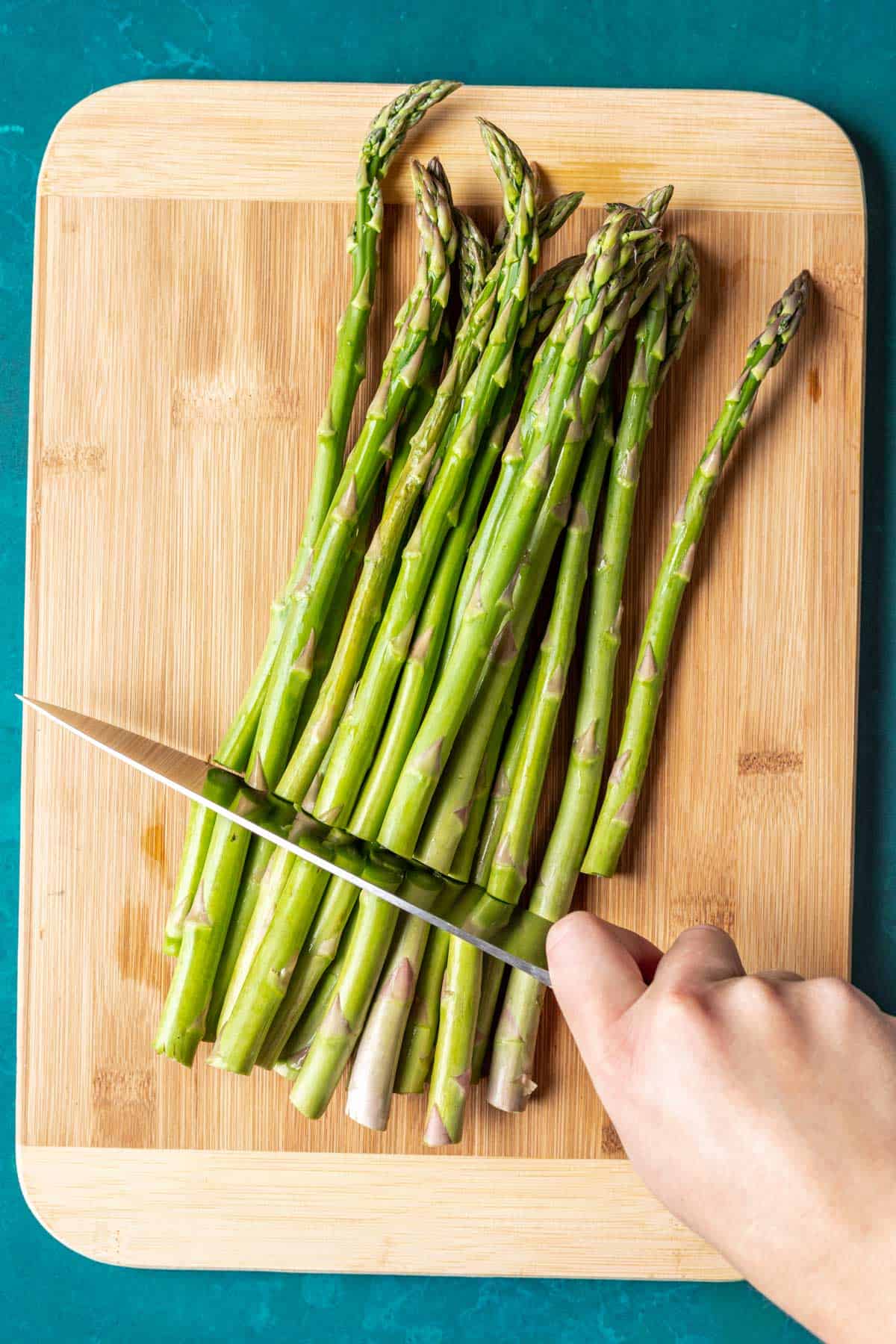 Cutting the ends off of asparagus stalks.