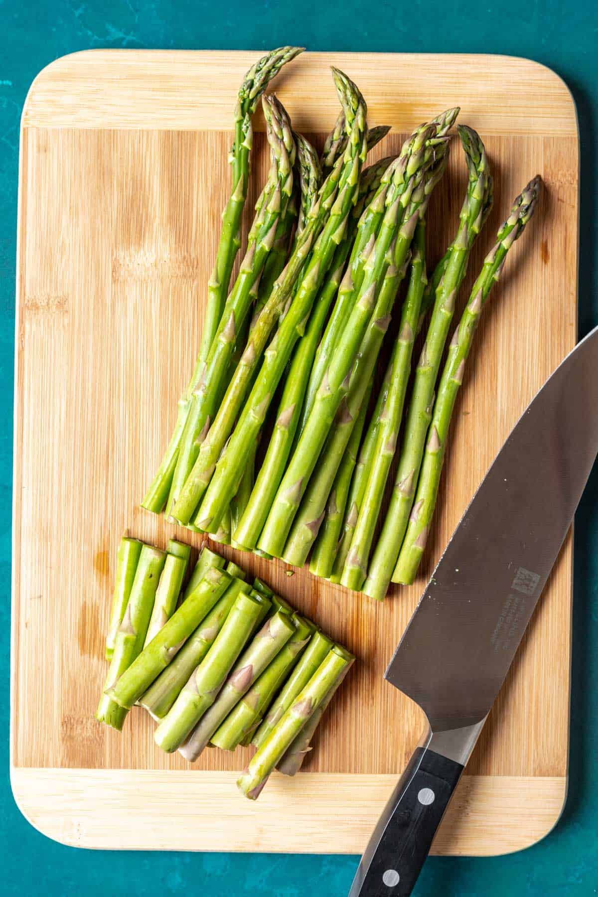 Asparagus on a cutting board with the ends cut off.