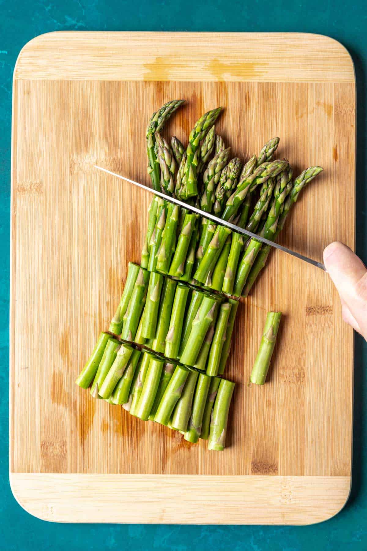 Chopping asparagus into smaller pieces.