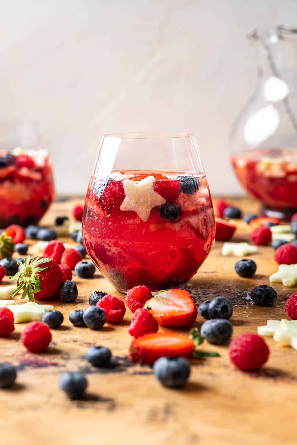 Berries and star shaped fruit in a wine glass with sangria.