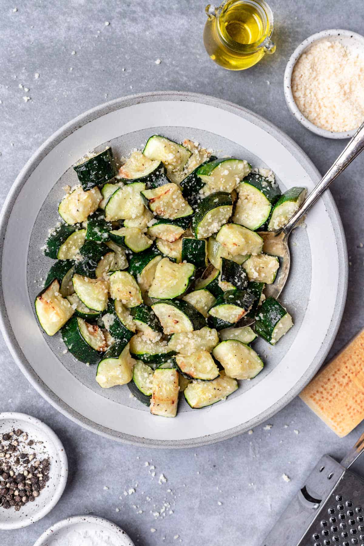 Air fryer zucchini in a serving bowl with a spoon.