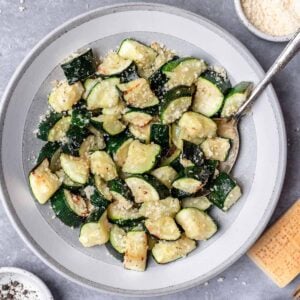 Air fryer zucchini in a serving bowl with a spoon.