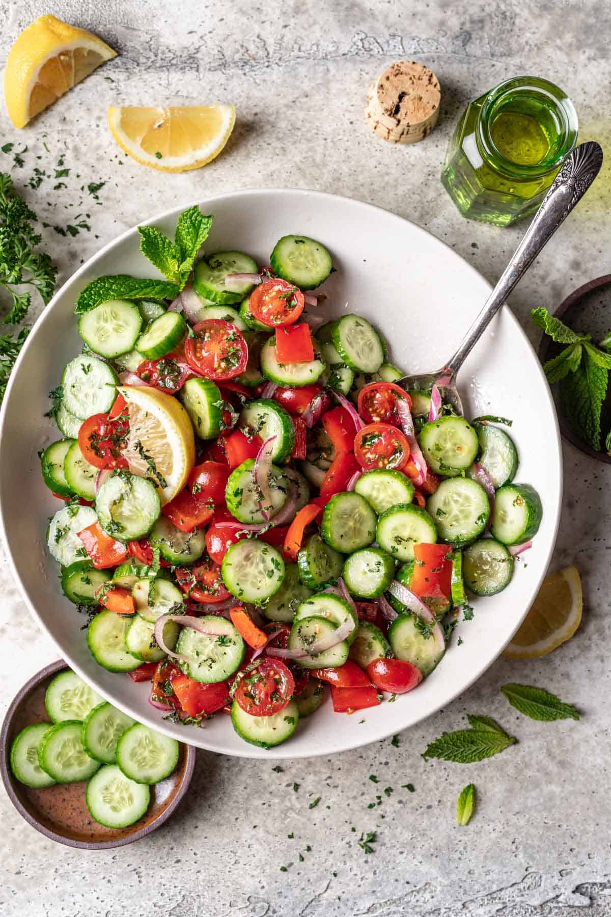 Jerusalem salad in a serving bowl with a spoon.