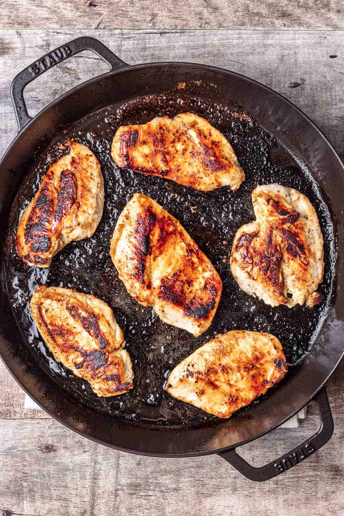 Golden brown chicken breasts cooked in a cast iron skillet.