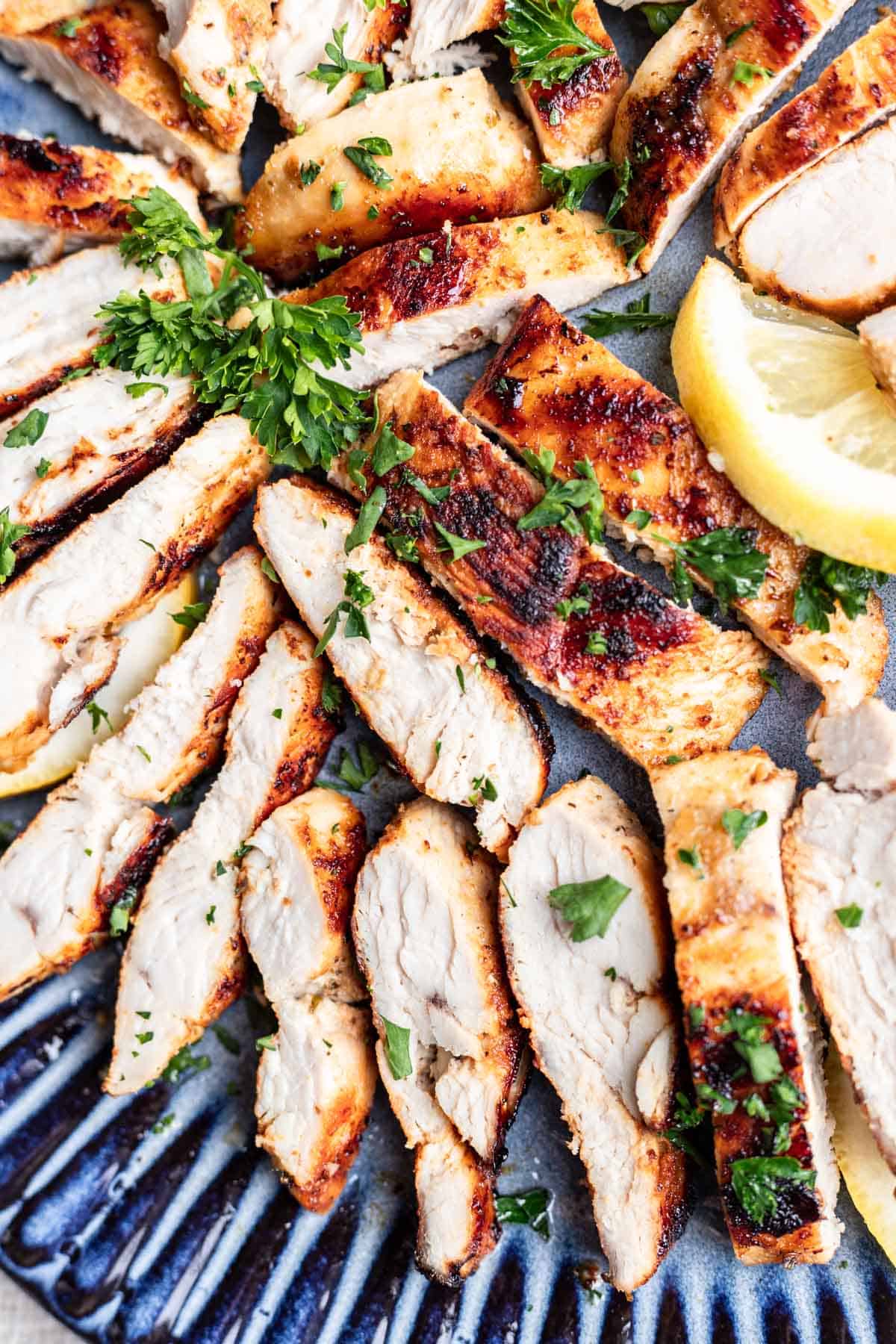 Cut pieces of chicken arranged on a blue plate.