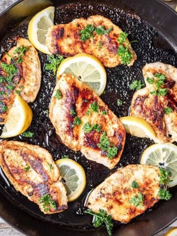 Golden brown chicken breasts cooked in a cast iron skillet.