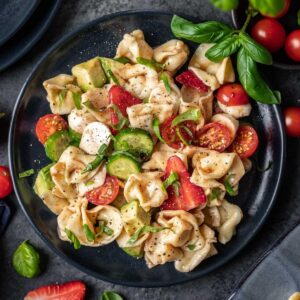 Summer tortellini caprese salad with fresh bail and cherry tomatoes.