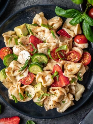 Summer tortellini caprese salad with fresh bail and cherry tomatoes.