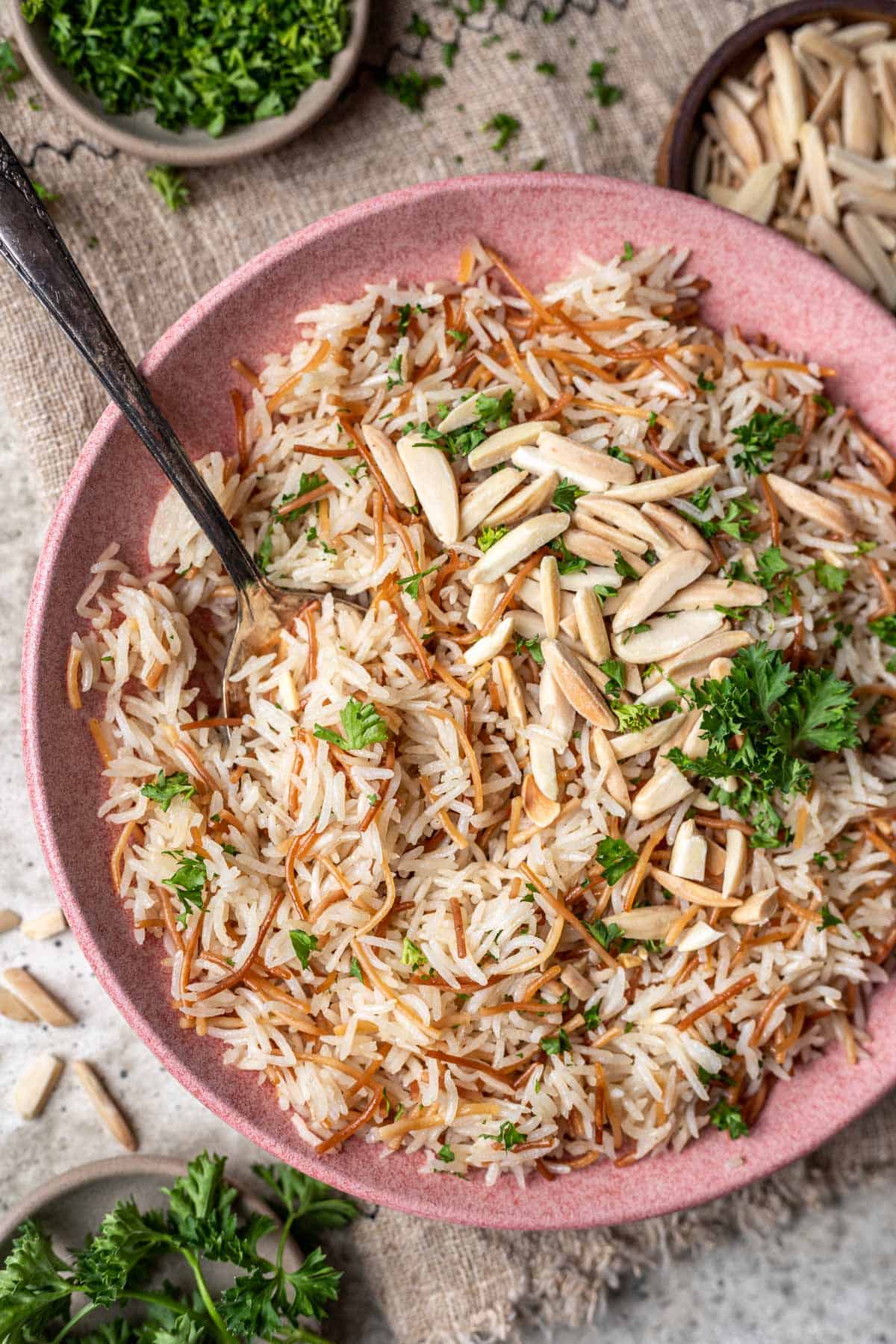 Instant pot rice pilaf garnished with toasted almonds and fresh parsley.