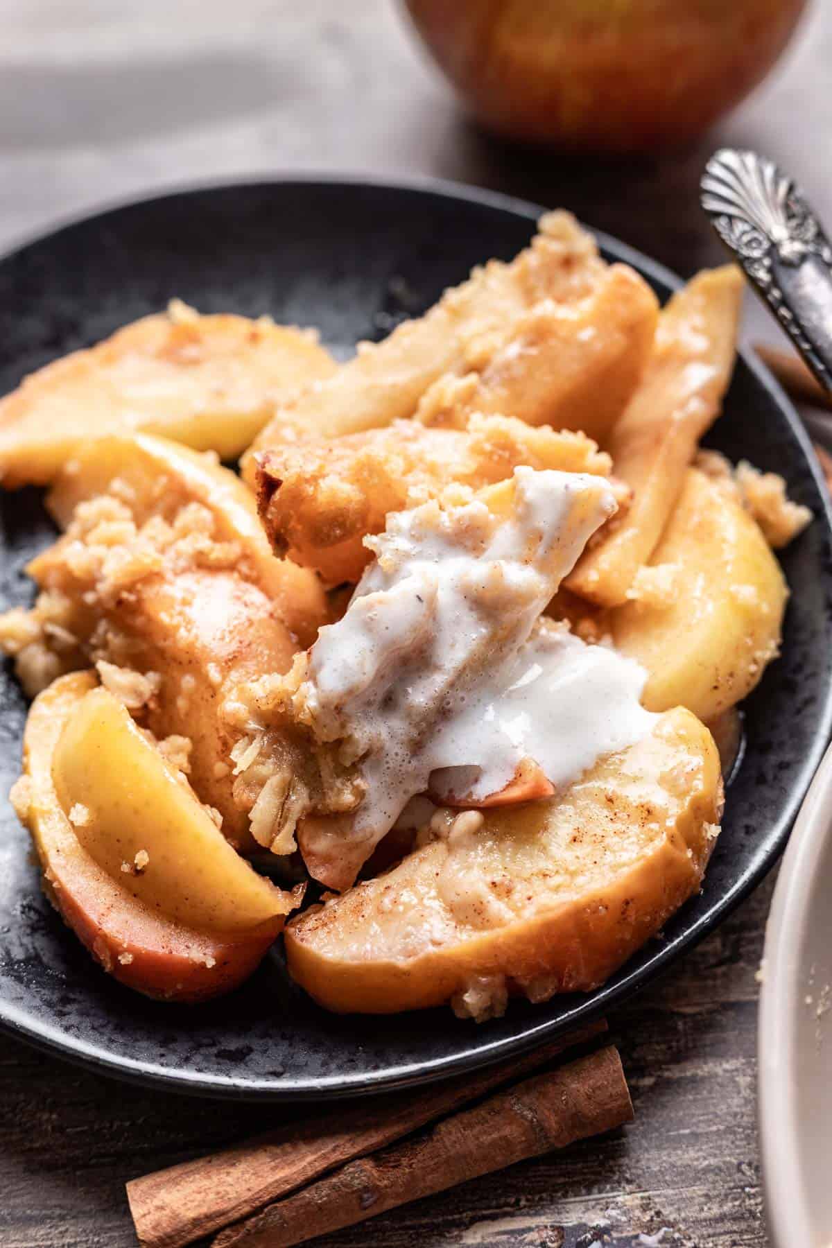 Air fryer apples on a plate with melted vanilla ice cream.