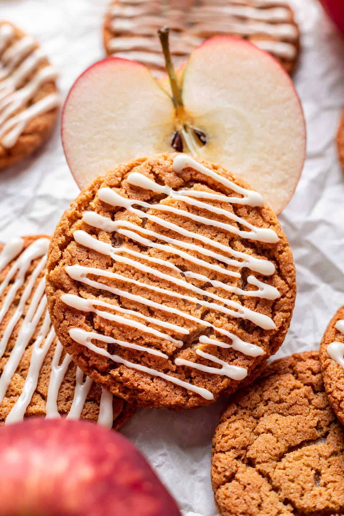 Chewy apple cider cookies resting on sliced apples.