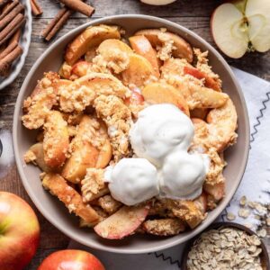 Air fryer apples in a serving bowl with scoops of ice cream on top.