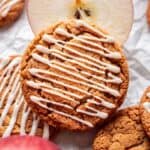Apple cider cookie resting on a sliced apple.