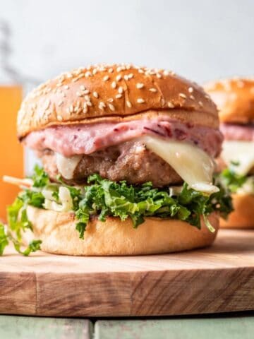 Apple turkey burger on a wood cutting board.