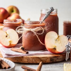 Instant pot apple butter in a glass jar with a spoon.