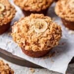 Pumpkin banana muffin with an oat crumble and sliced banana on top.
