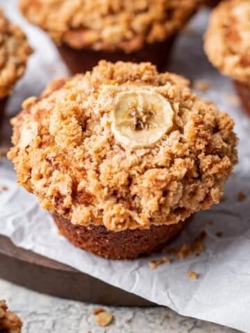 Pumpkin banana muffin with an oat crumble and sliced banana on top.