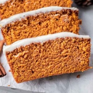 Sliced pumpkin bread with cream cheese frosting.