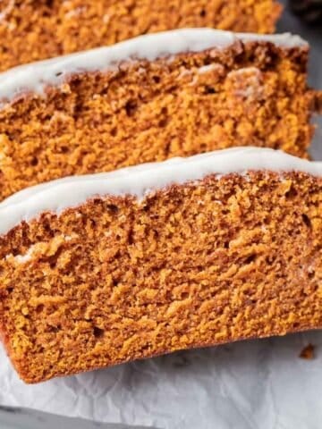 Sliced pumpkin bread with cream cheese frosting.