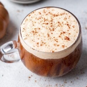 Pumpkin cream cold foam in a glass mug dusted with pumpkin pie spice over top.