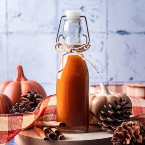 Pumpkin spice simple syrup in a bottle on a serving tray.