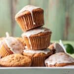 Pumpkin zucchini muffins stacked on top of each other.