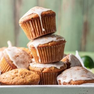 Pumpkin zucchini muffins stacked on top of each other.