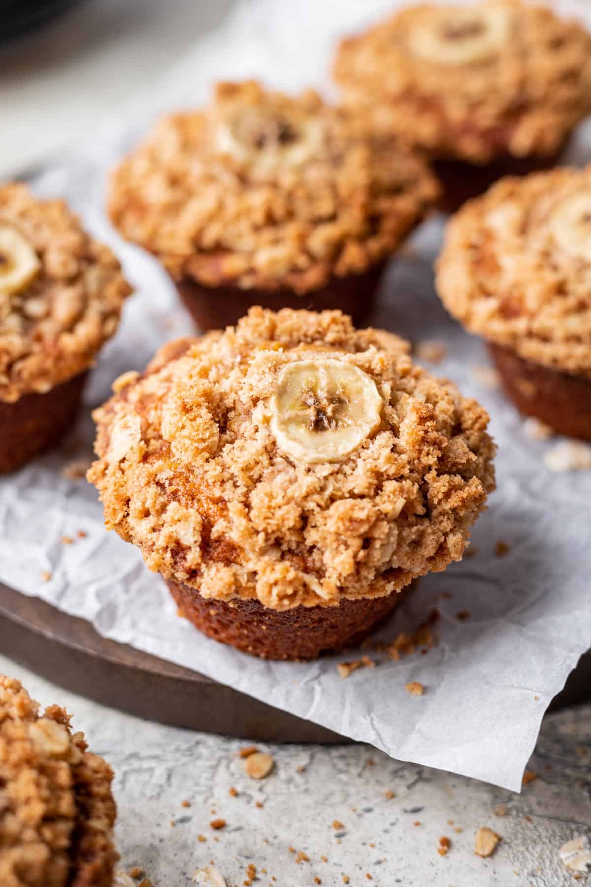 Pumpkin banana muffins topped with an oat crumble and a sliced banana.