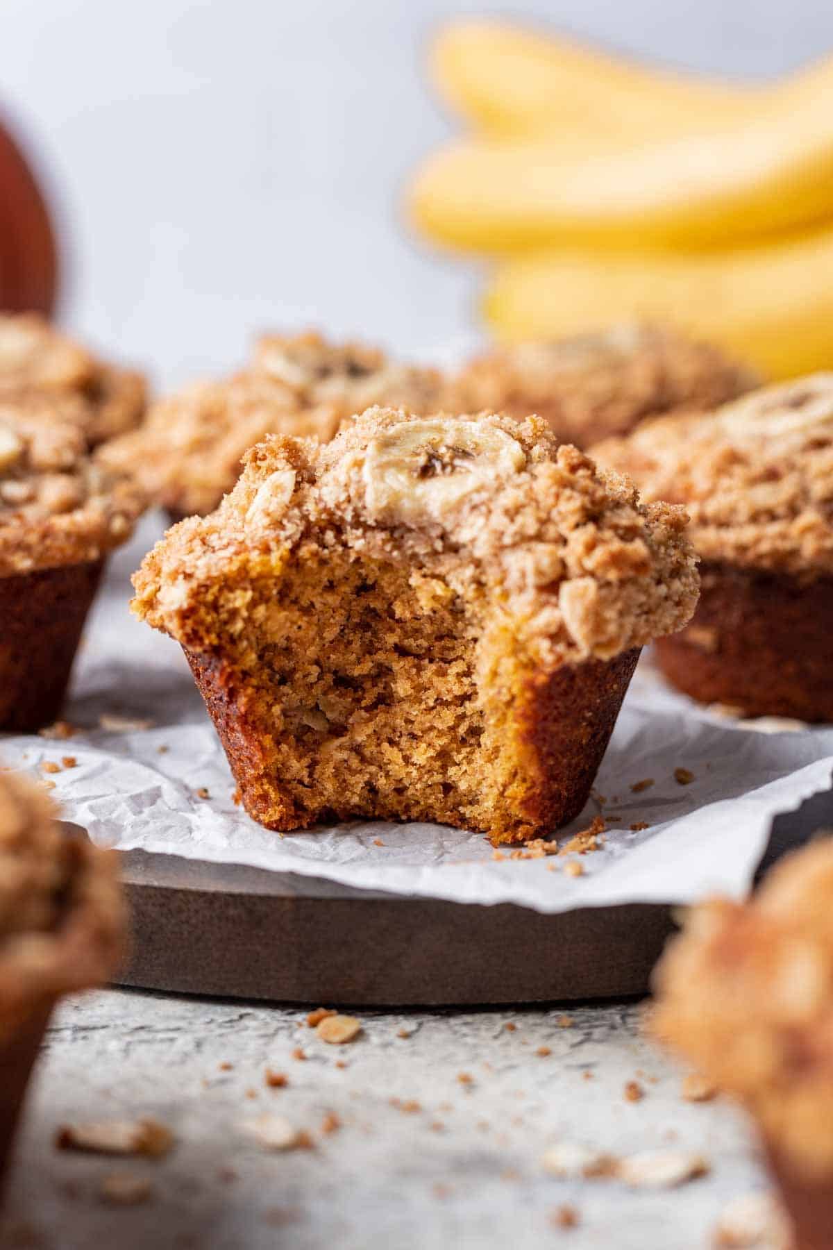 Pumpkin banana muffin with a bite taken out to show the fluffy center.