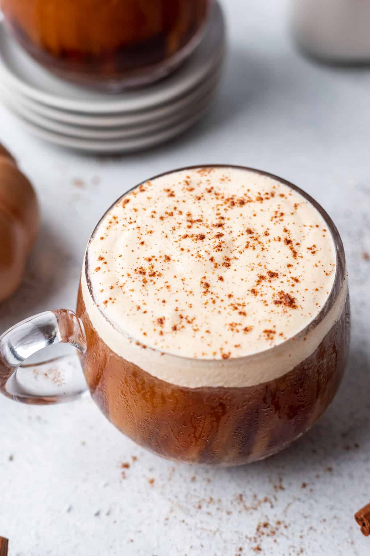 Pumpkin cream cold foam in a glass mug dusted with pumpkin pie spice over top.