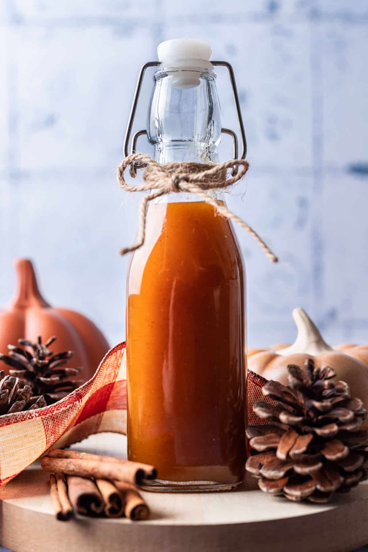 A clear bottle filled with pumpkin spice simple syrup.
