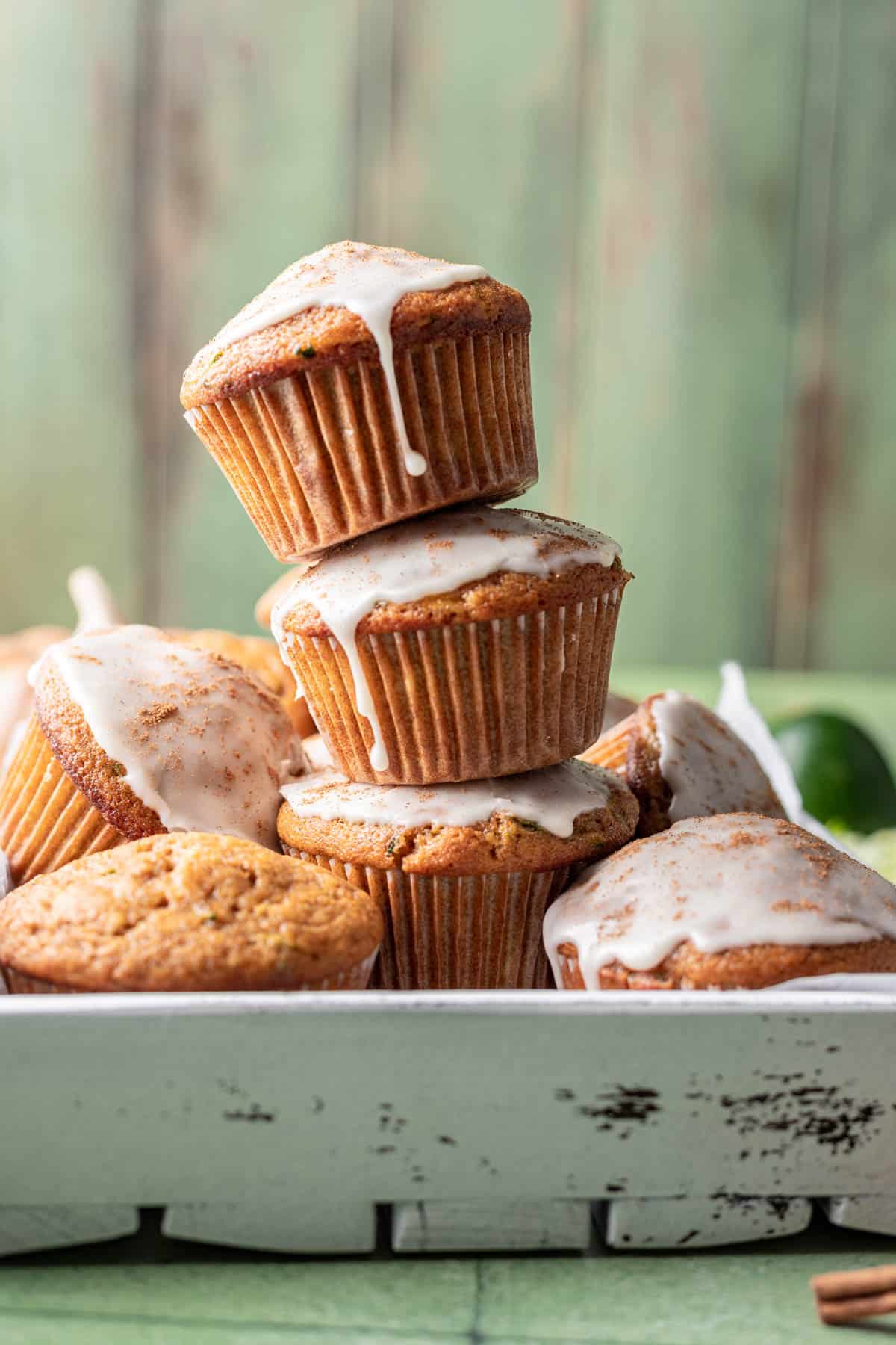Pumpkin zucchini muffins stacked on top of each other.