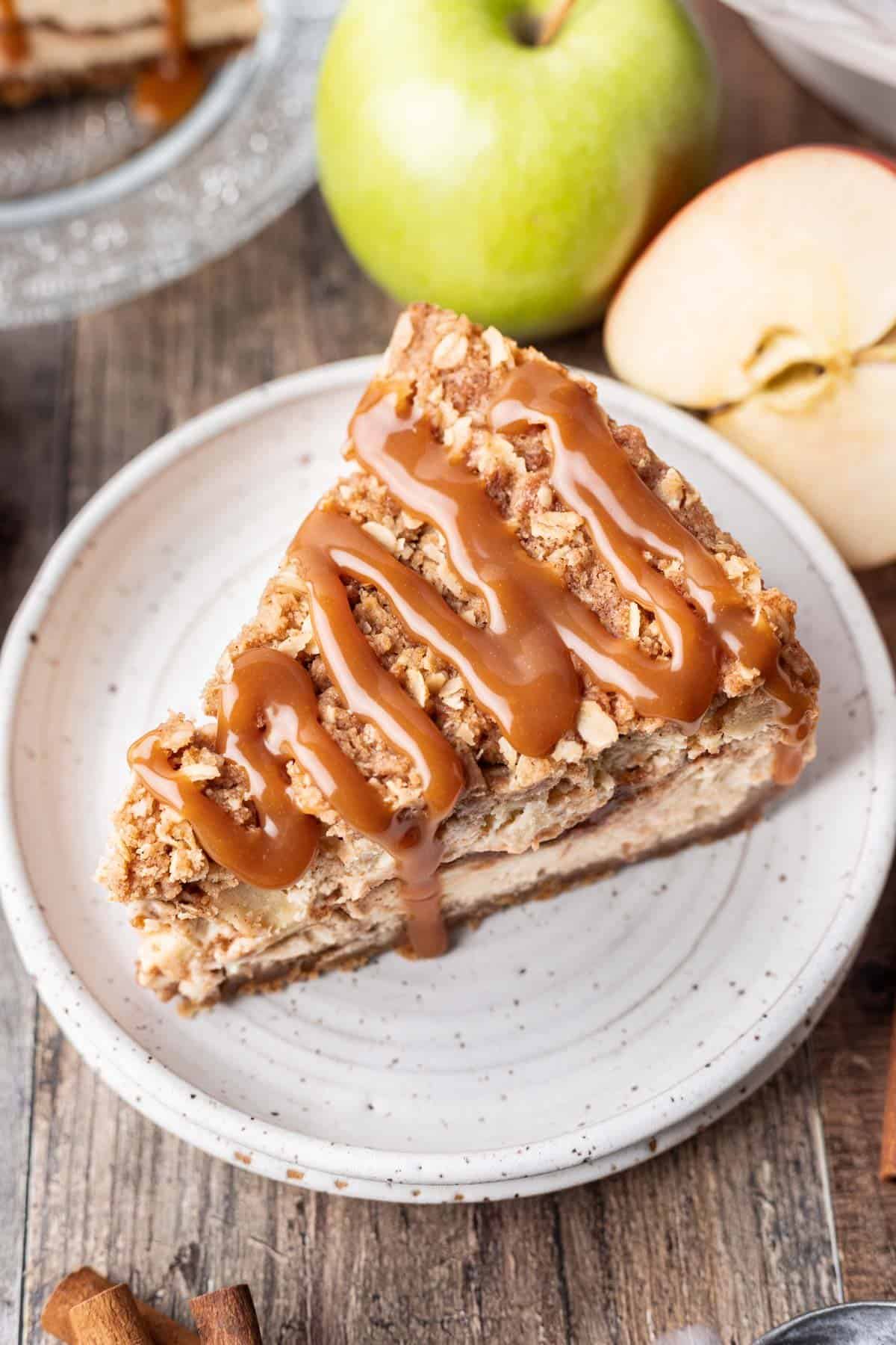 Apple crumble cheesecake drizzled with caramel over top.
