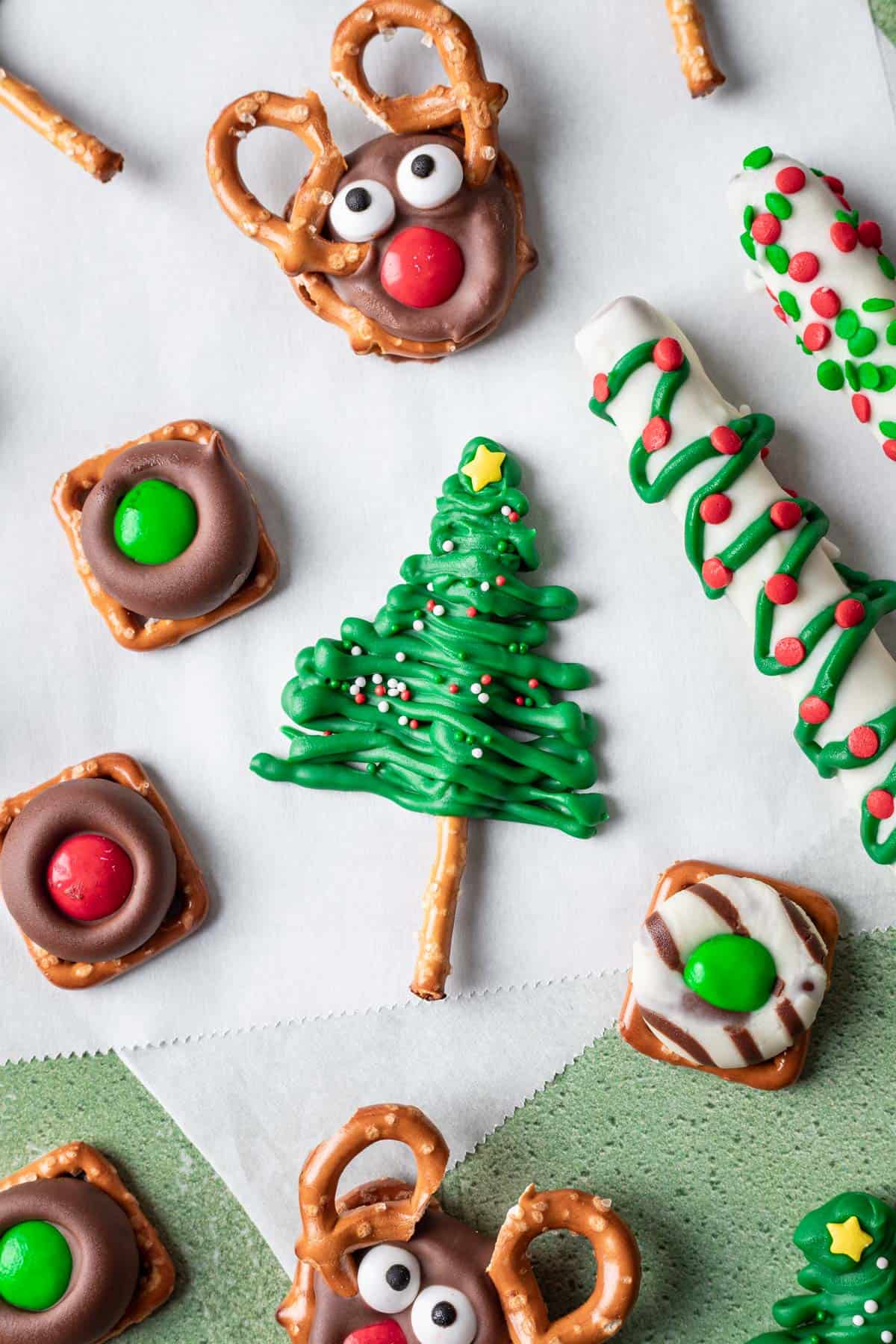 Christmas tree pretzels arranged with reindeer pretzels, chocolate covered pretzel rods, and other christmas pretzels.