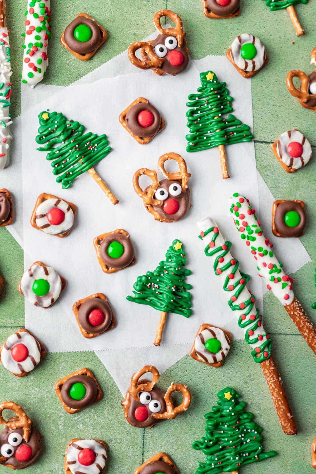 5 different types of Christmas pretzels arranged on a green and white backdrop.