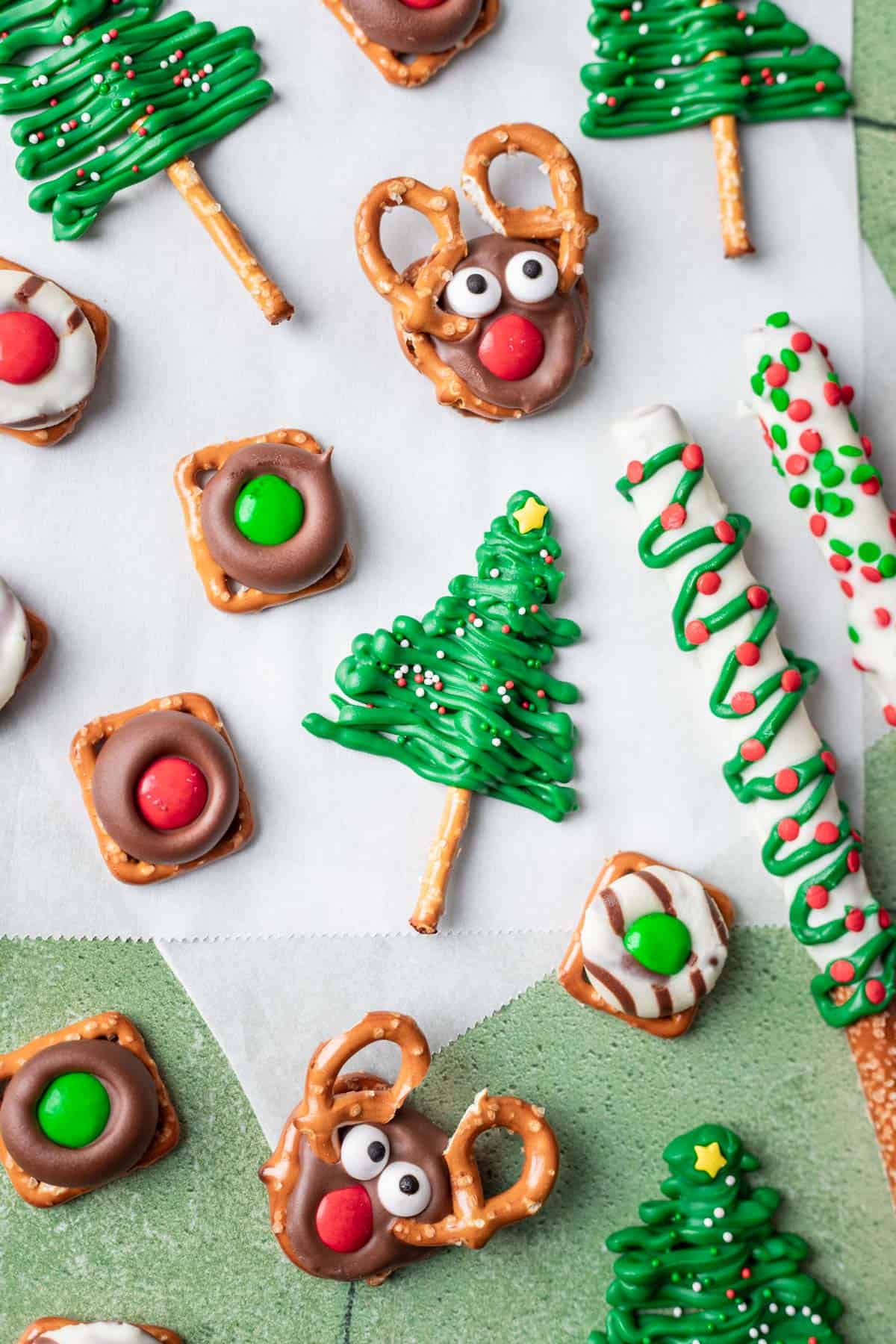 Christmas pretzels 5 different ways on a green and white backdrop.