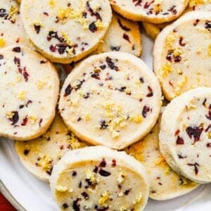 Cranberry orange shortbread cookies stacked on a plate.