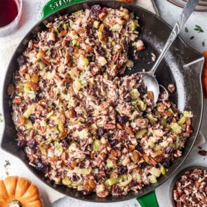 Thanksgiving wild rice in a skillet with a serving spoon.