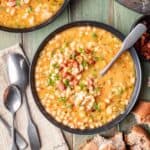 Instant pot navy bean soup in a bowl with a spoon.