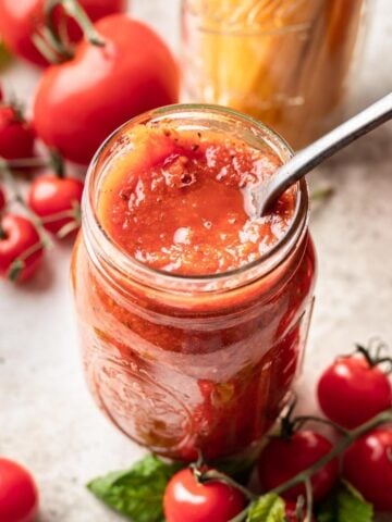 Instant pot tomato sauce in a glass jar with a spoon.