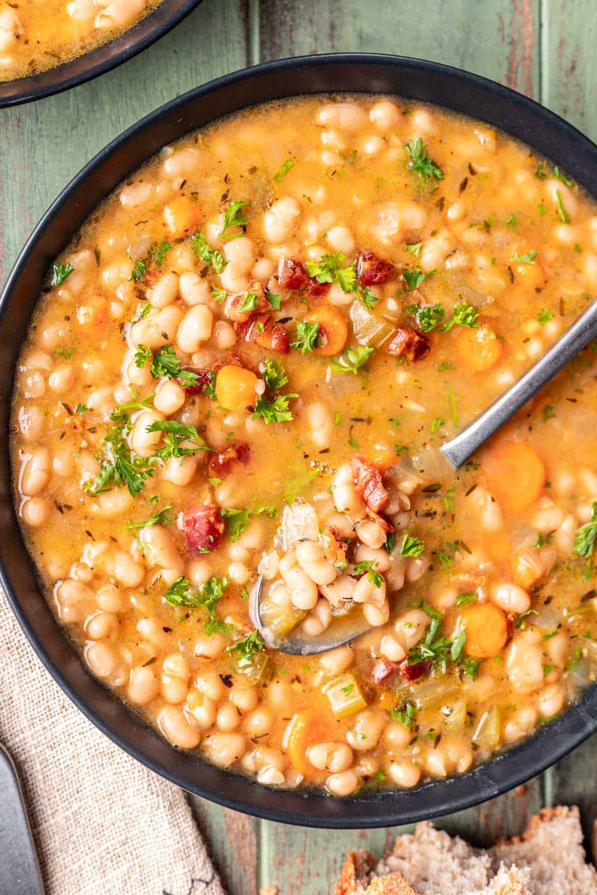 Instant pot navy bean soup in a bowl with a spoon.