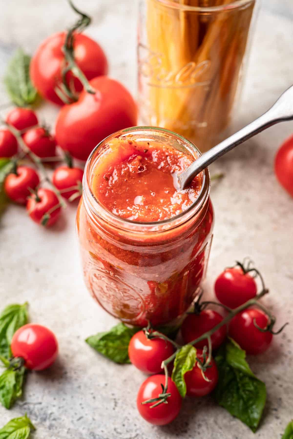 Instant pot tomato sauce in a jar with a spoon.