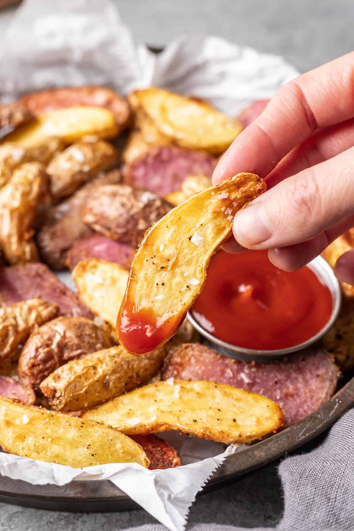 Air fryer fingerling potato with seasonings and ketchup.