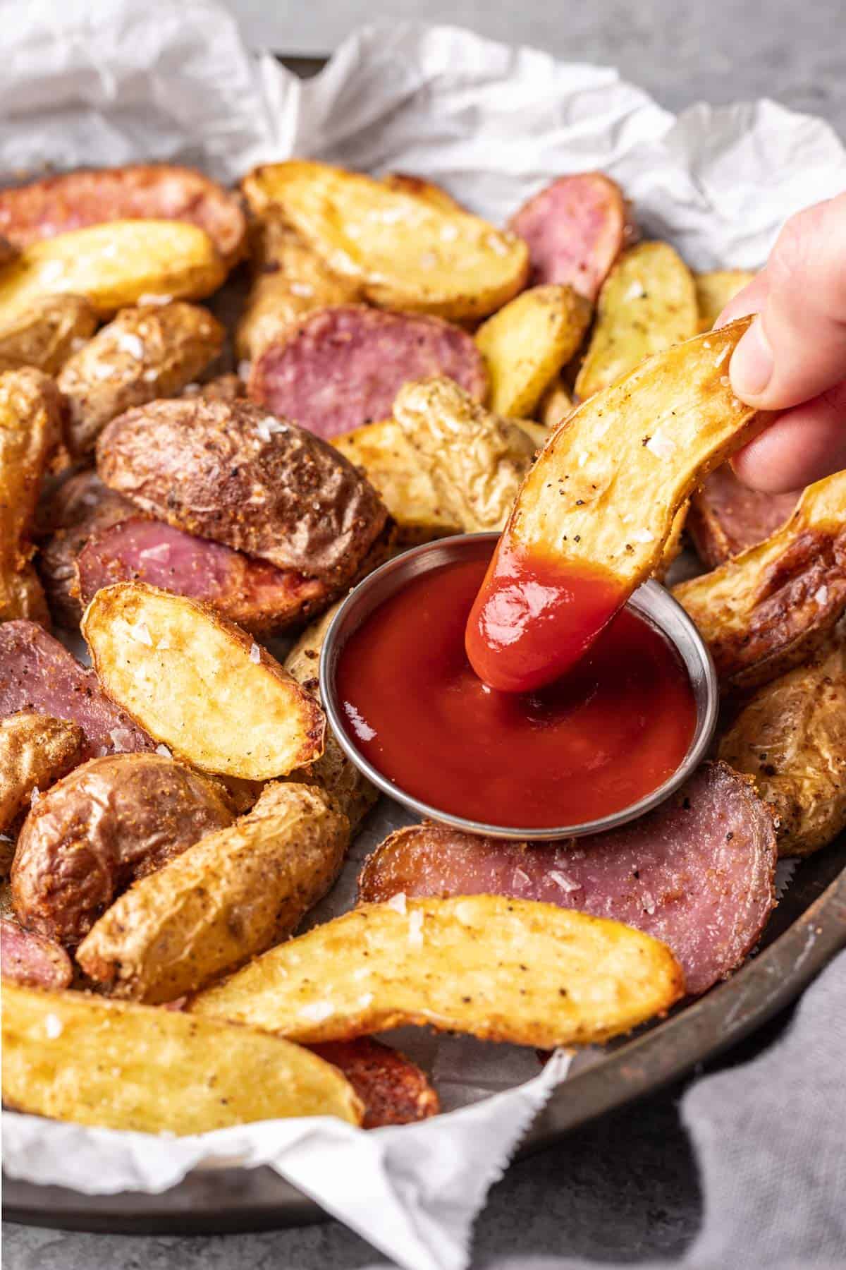 Air fryer fingerling potato dipped in ketchup.