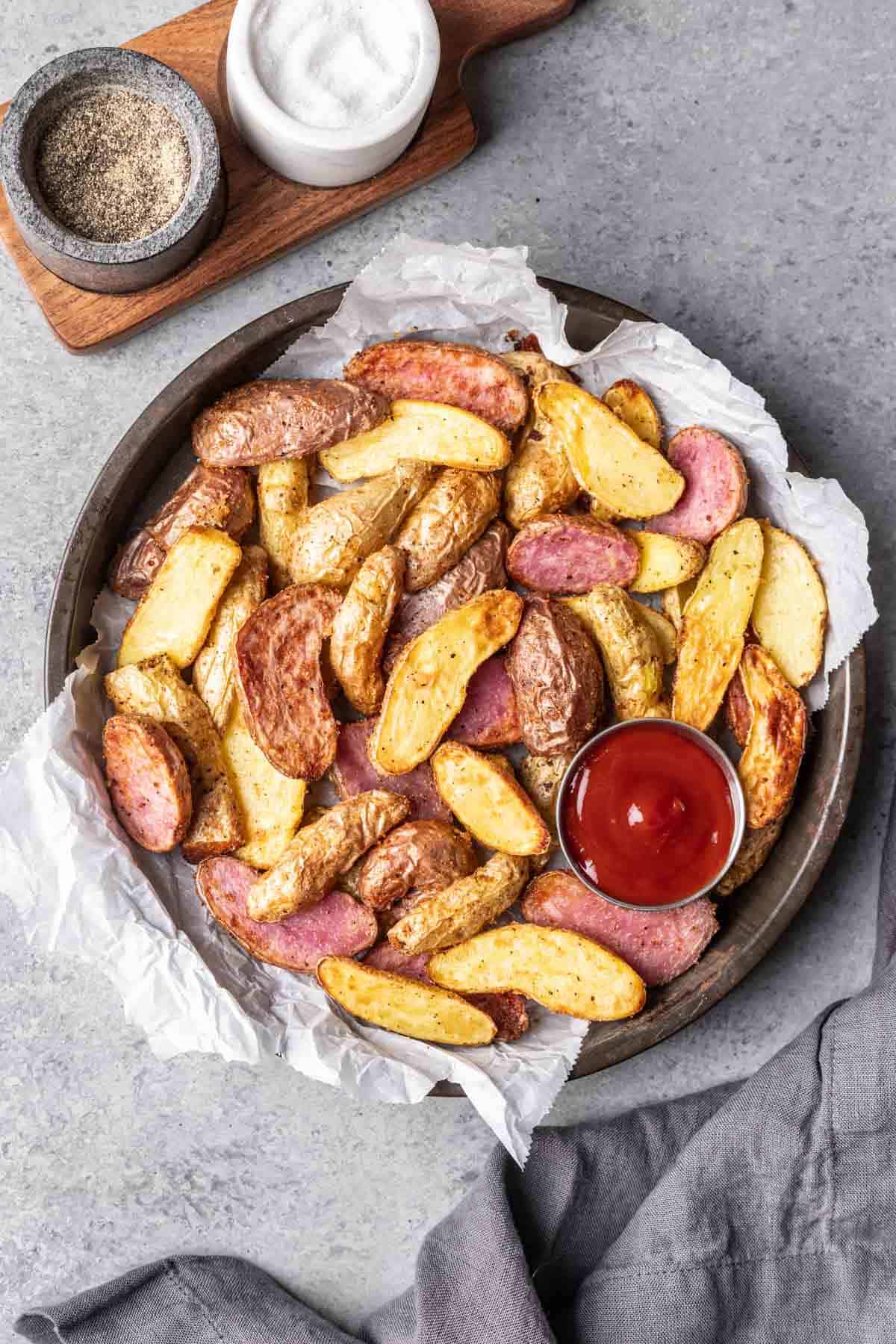 Air fryer fingerling potatoes on a serving platter with a side of ketchup for dipping.